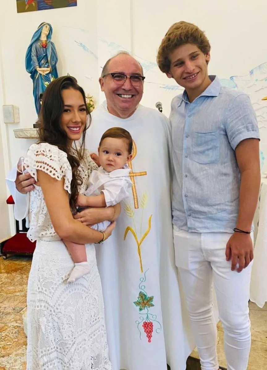 Maria Clara Quinderé e David Rodrigues levam o filho David à pia batismal