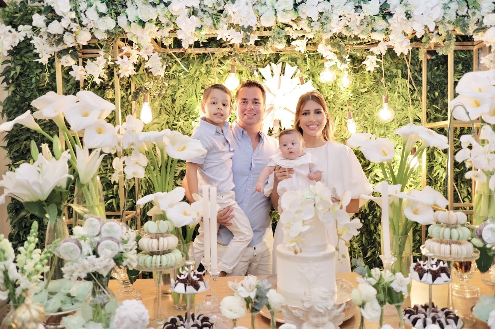 Tayra Romcy e Léo Aguiar levam o filho Heitor à pia batismal