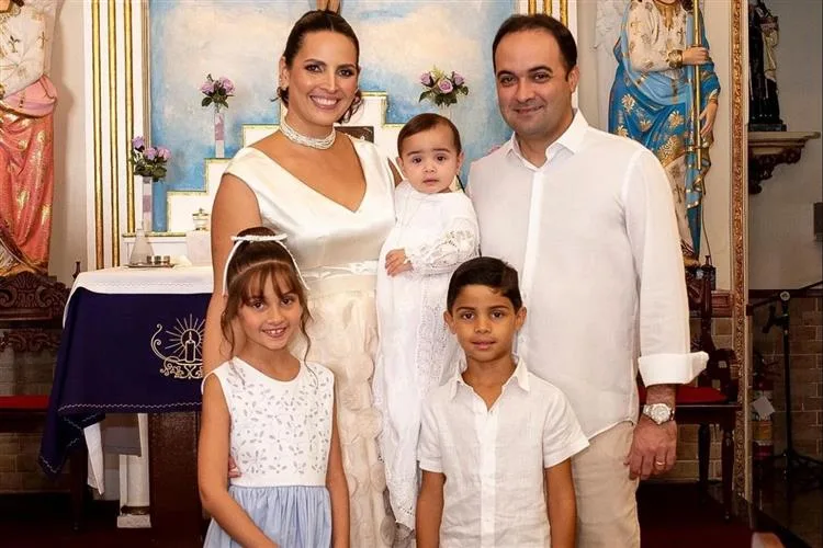 Mariana Queiroz e Felipe Gurgel levam o filho Henrique à pia batismal