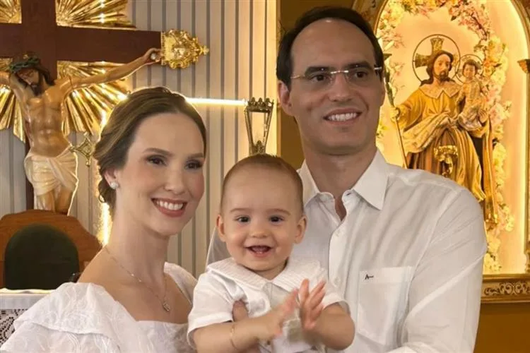 Livia e Aristófanes Canamary levam o filho João Guilherme à pia batismal