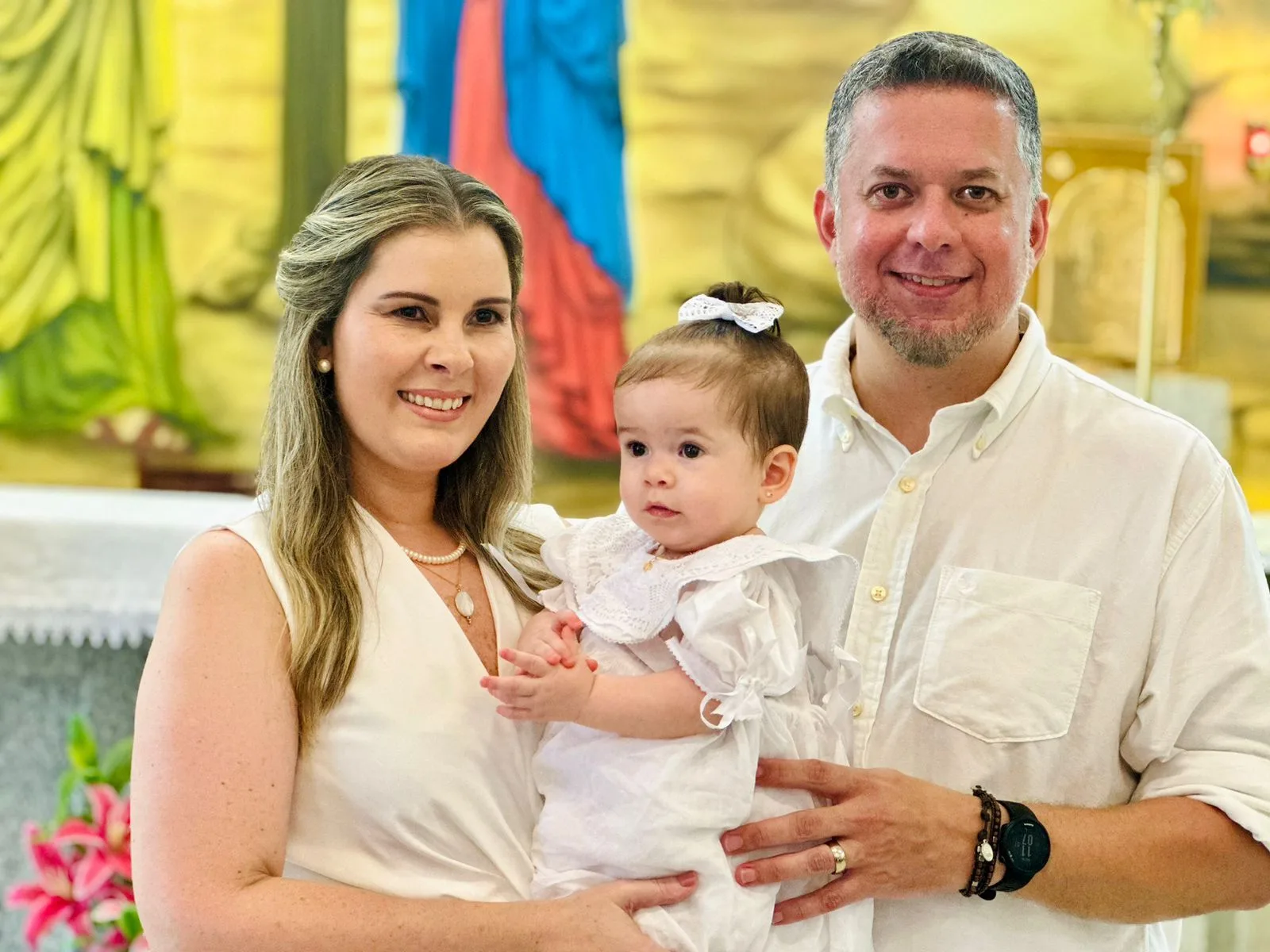 Adriana e Raphael Loureiro levam a filha Maria à pia batismal