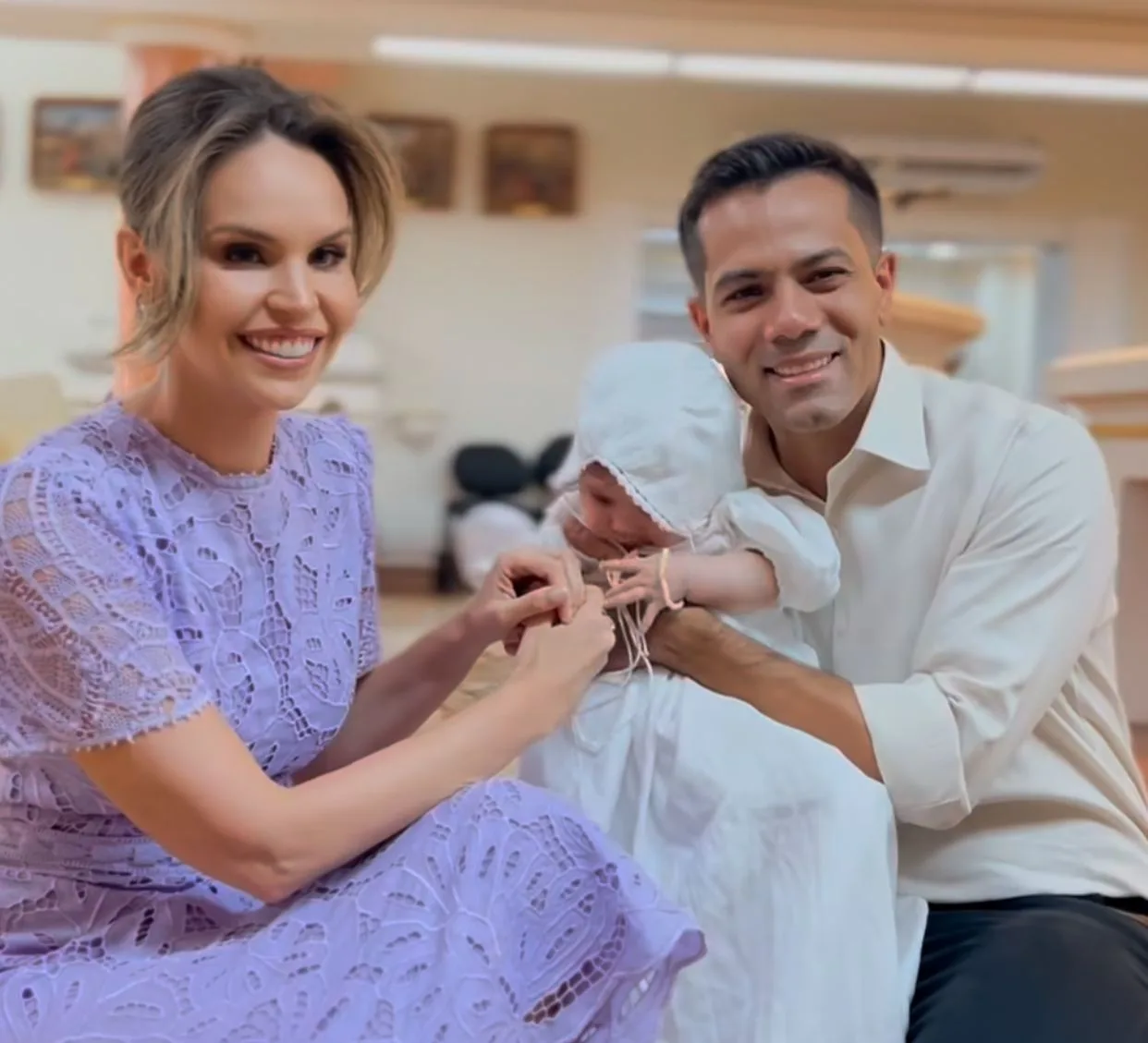 Gabriella Aguiar e Cláudio Leite encaminham Sara à pia batismal