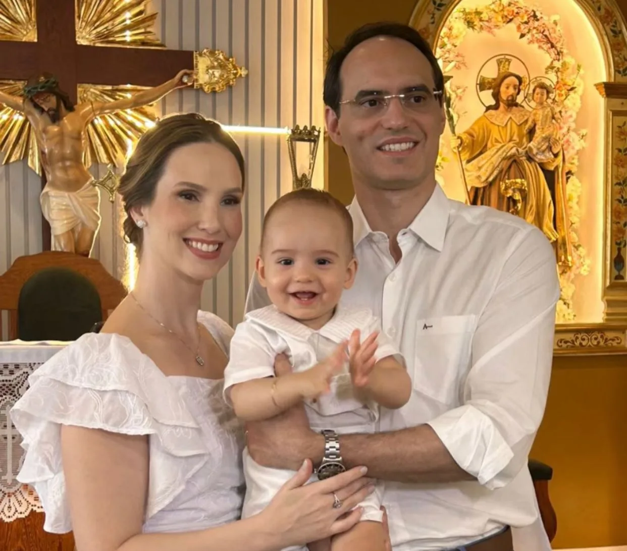 Livia e Aristófanes Canamary levam o filho João Guilherme à pia batismal